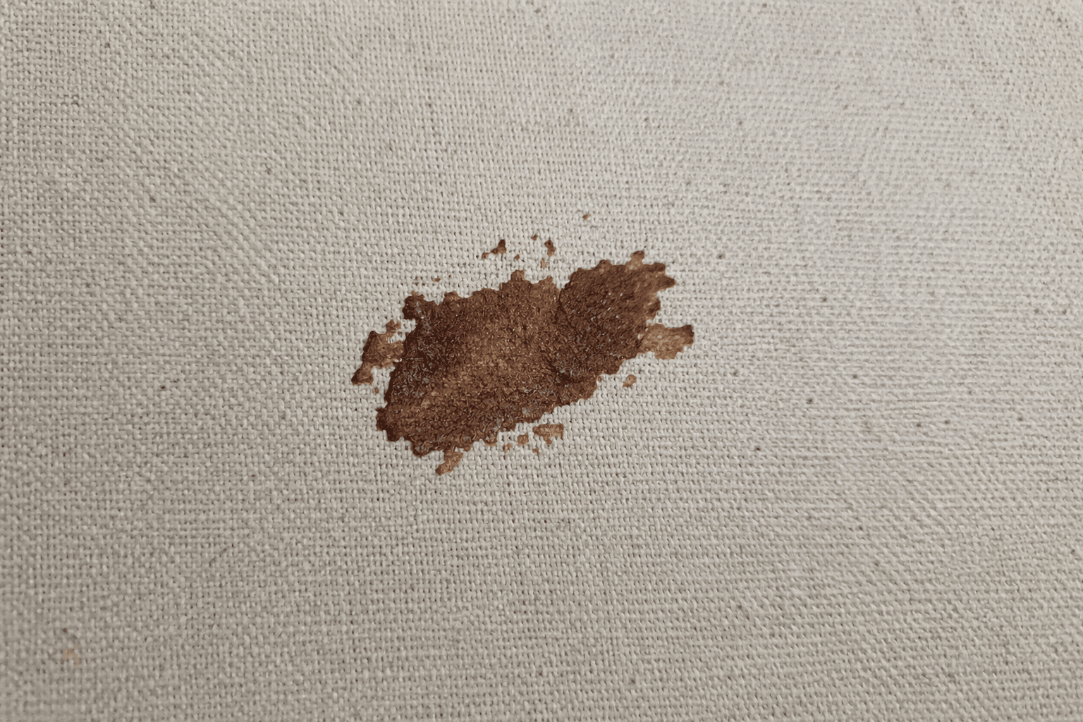 Aangekoekte ingedroogde chocoladevlek op een stoffen bank