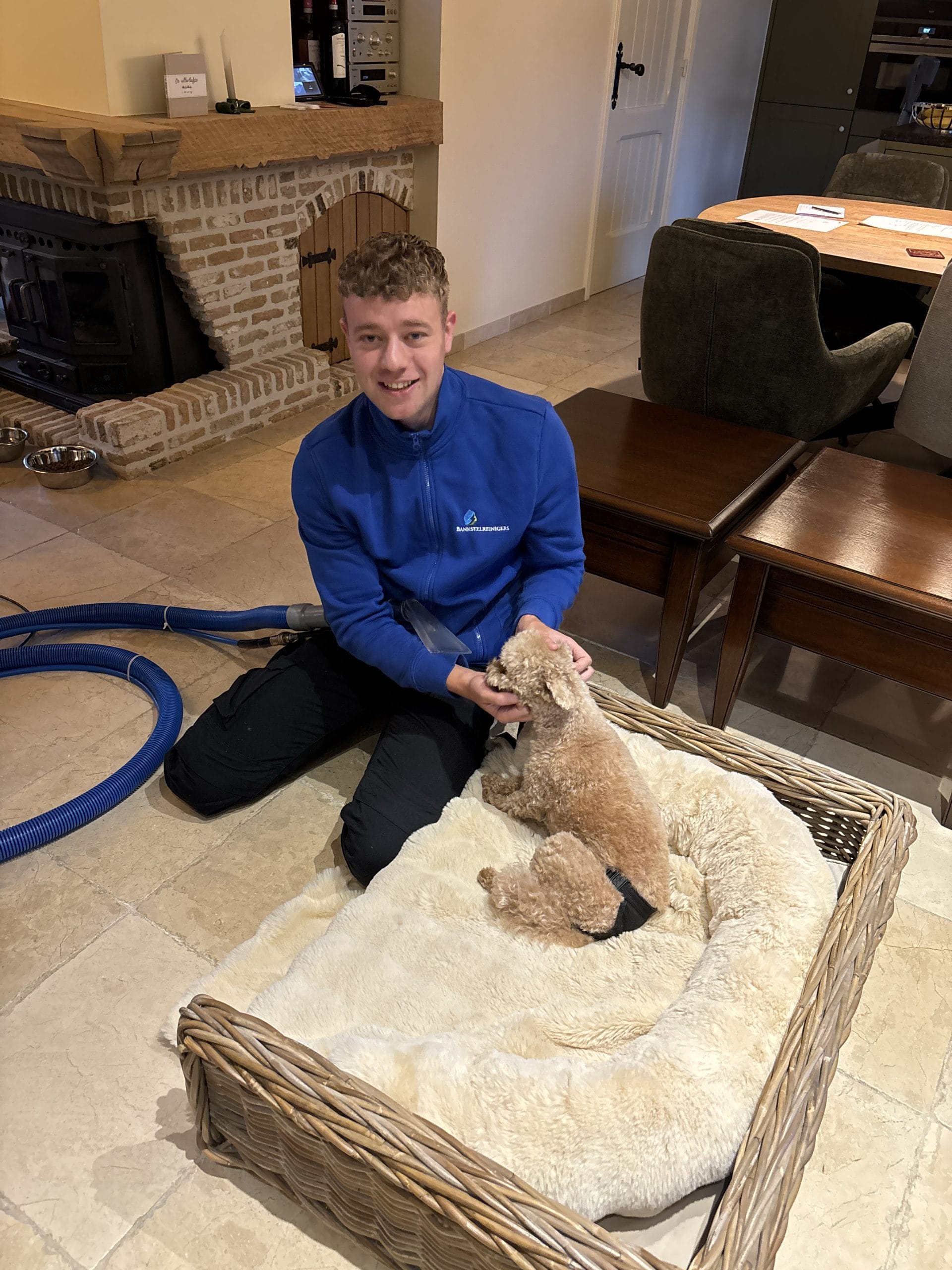 Dennis aait een hond naast zijn pas gereinigde hondenmand