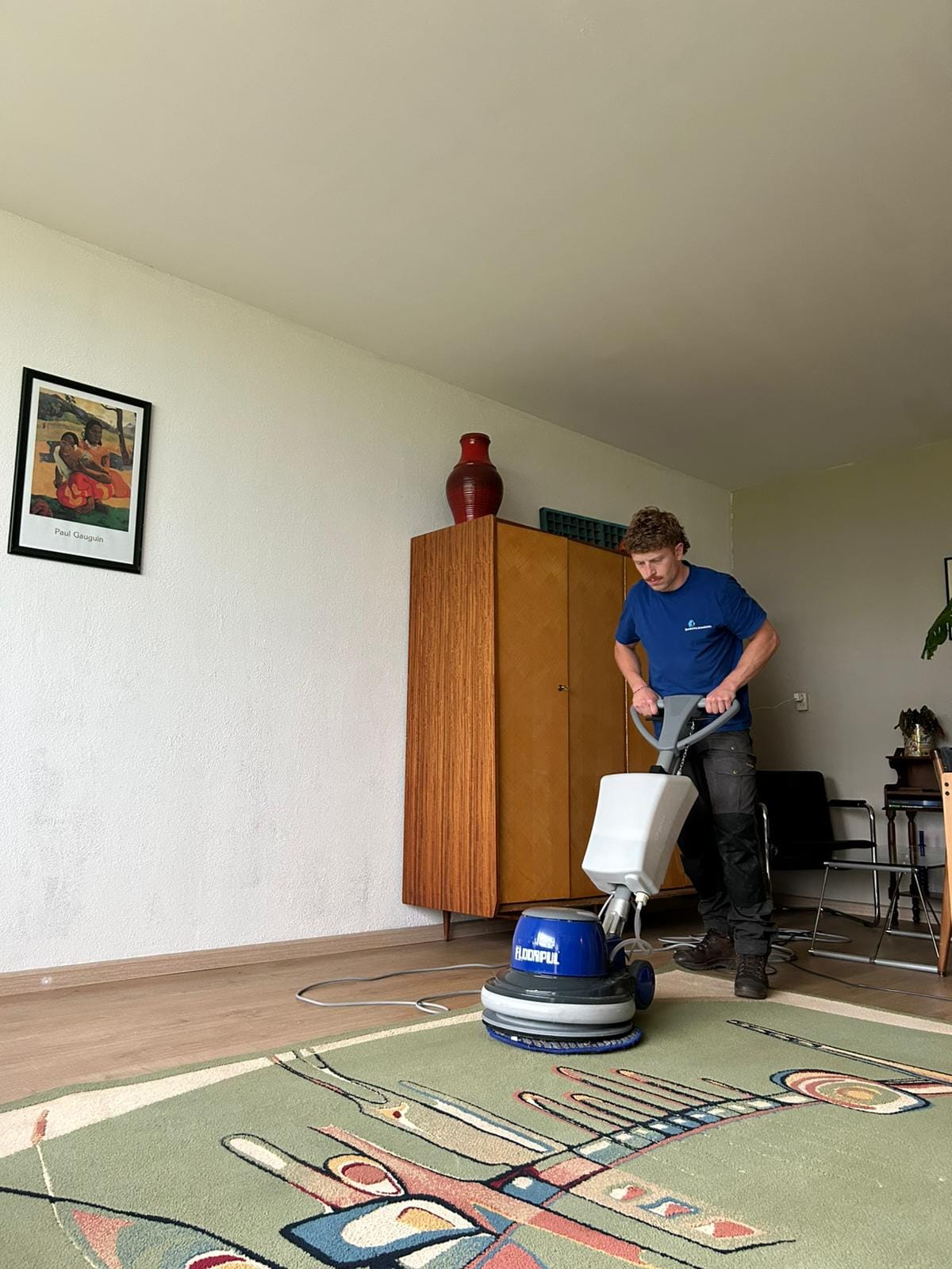 Rowan van Bankstelreinigers reinigt een vloerkleed aan huis met de vloermachine