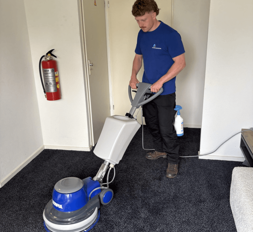 Rowan reinigt professioneel een tapijt met een eenschijfmachine