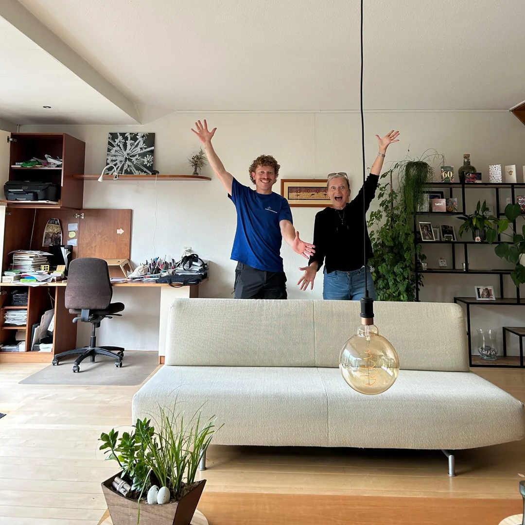 Blije klant met onze medewerker bij de gereinigde bank in de woonkamer